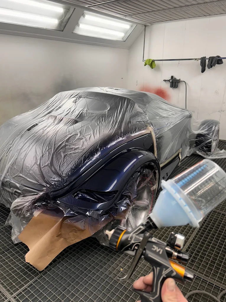 Paint being applied to a vehicle in the spray booth